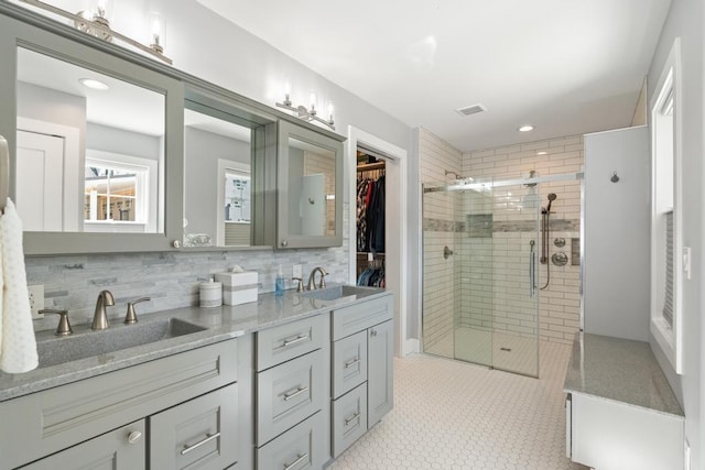 135 Beaubien Ave, Petoskey, MI 49770 - full bathroom featuring double vanity, a stall shower, tasteful backsplash, recessed lighting, and a walk in closet