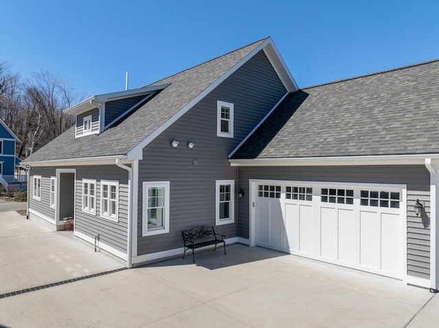 135 Beaubien Ave, Petoskey, MI 49770 - back of property with concrete driveway, a shingled roof, and an attached garage