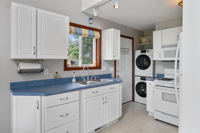 15700 Island Dr, Wolverine, MI 49799 - kitchen featuring stacked washer and clothes dryer, white appliances, dark countertops, and white cabinets