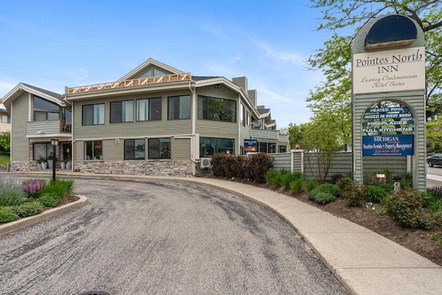 101 Michigan Ave Unit 107, Charlevoix, MI 49720 - view of front of house featuring stone siding and a chimney