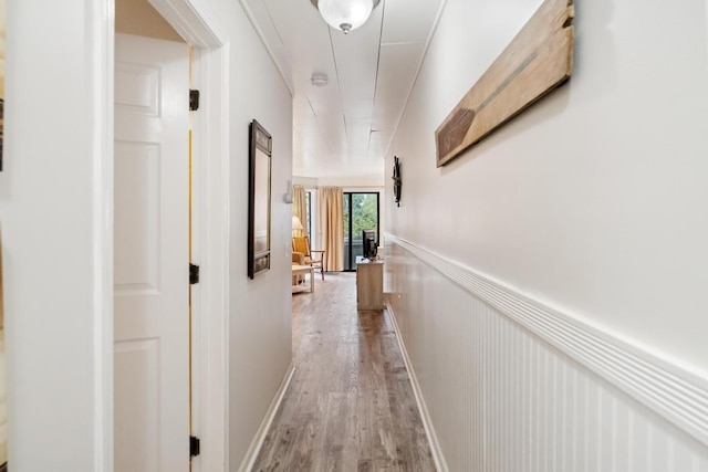 101 Michigan Ave Unit 107, Charlevoix, MI 49720 - hallway with light wood-style floors and wainscoting