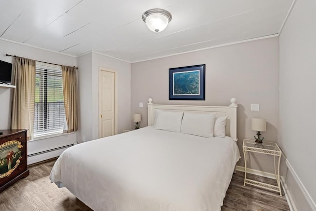 101 Michigan Ave Unit 107, Charlevoix, MI 49720 - bedroom with baseboard heating, wood finished floors, and ornamental molding