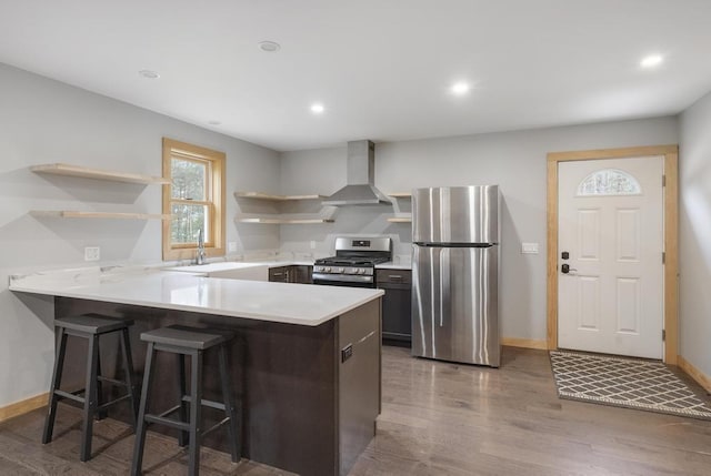 168 Townline Rd, Pellston, MI 49769 - kitchen featuring open shelves, appliances with stainless steel finishes, wall chimney exhaust hood, a peninsula, and wood finished floors