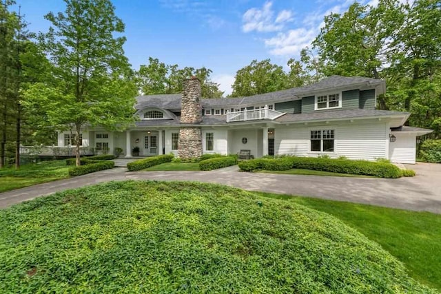 145 Traverse St, Harbor Springs, MI 49740 - view of front facade with a chimney, a balcony, and a front lawn
