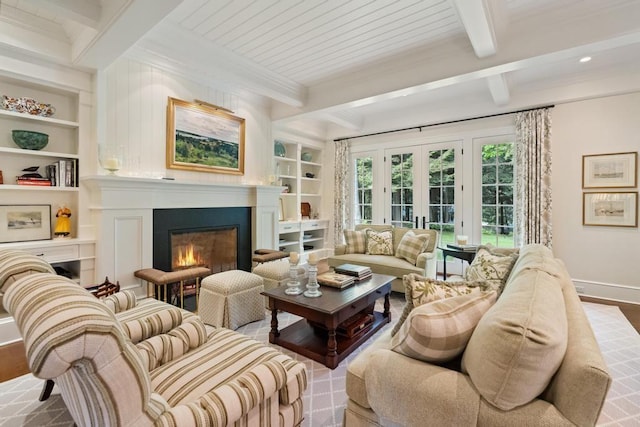 145 Traverse St, Harbor Springs, MI 49740 - living area with a glass covered fireplace, built in features, beam ceiling, crown molding, and wood finished floors