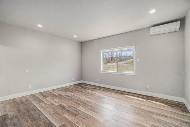 705 Maple Crk, Petoskey, MI 49770 - spare room with a wall unit AC, wood finished floors, and recessed lighting