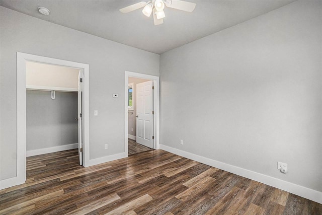 705 Maple Crk, Petoskey, MI 49770 - unfurnished bedroom with wood finished floors, a walk in closet, a closet, and a ceiling fan