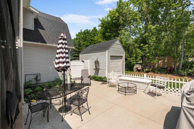 1116 N Lake St, Boyne City, MI 49712 - view of patio / terrace with outdoor dining space, an outbuilding, and a garage