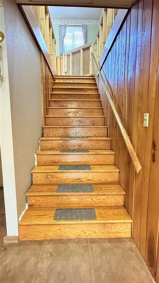 2160 Kladder Rd, Bellaire, MI 49615 - stairs featuring a textured wall and wood walls