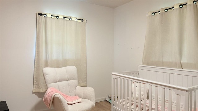 2160 Kladder Rd, Bellaire, MI 49615 - bedroom featuring wood finished floors and a nursery area