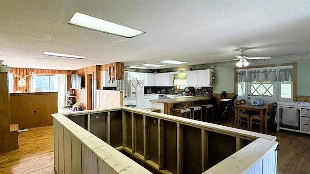 2160 Kladder Rd, Bellaire, MI 49615 - kitchen with white fridge with ice dispenser, white cabinets, a textured ceiling, light wood-type flooring, and healthy amount of natural light