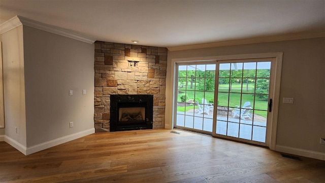 6069 Hills Cottage Ct Unit 5, Bay Harbor, MI 49770 - unfurnished living room featuring crown molding, wood finished floors, and a stone fireplace