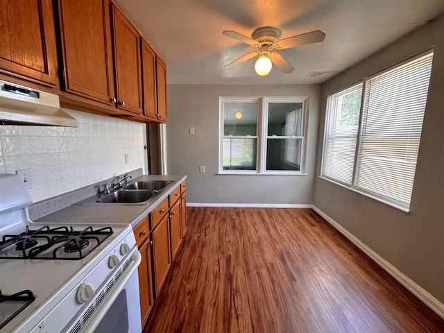 2343 Bonner Rd, Ferndale, MI 48220 - kitchen featuring gas range gas stove, under cabinet range hood, brown cabinets, and decorative backsplash