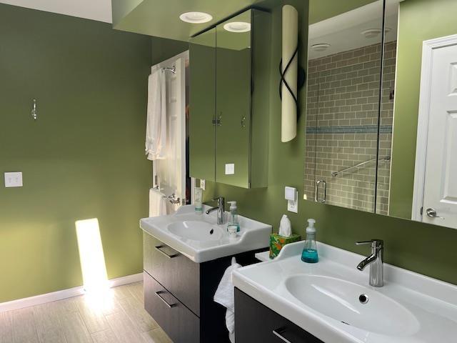700 Fairways Dr Unit 14, Harbor Springs, MI 49740 - bathroom featuring two vanities and baseboards