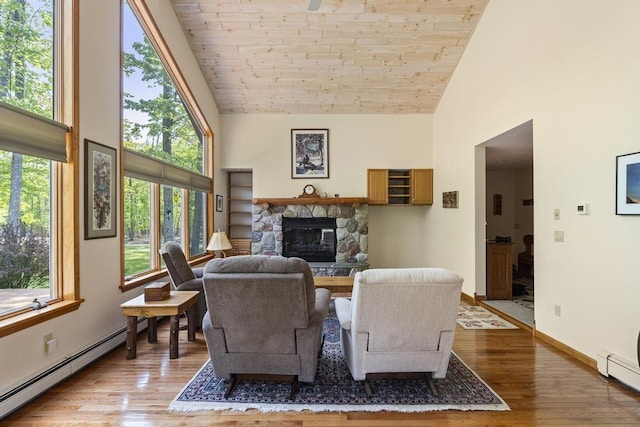 6989 Meadowlark Way, Gaylord, MI 49735 - living room with high vaulted ceiling, baseboard heating, wood finished floors, plenty of natural light, and a fireplace