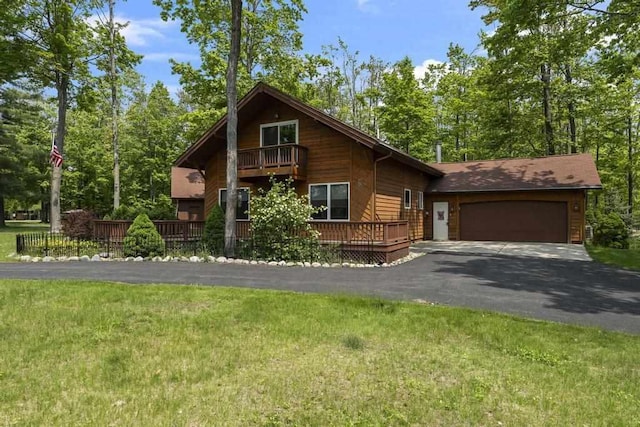 6989 Meadowlark Way, Gaylord, MI 49735 - chalet / cabin with driveway, a garage, a front yard, and a balcony