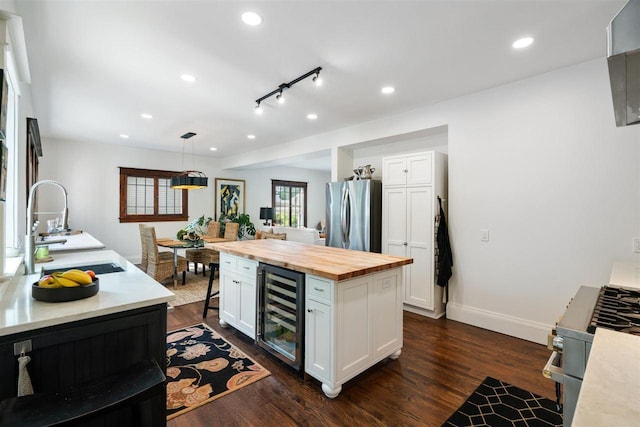 606 State St, Petoskey, MI 49770 - kitchen featuring wine cooler, wooden counters, stainless steel appliances, white cabinetry, and recessed lighting