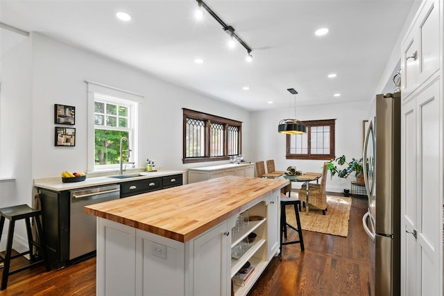 606 State St, Petoskey, MI 49770 - kitchen featuring appliances with stainless steel finishes, butcher block counters, a kitchen island, dark wood finished floors, and recessed lighting