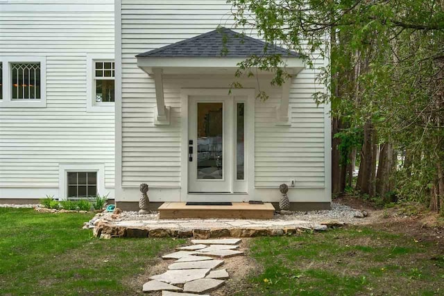 606 State St, Petoskey, MI 49770 - property entrance with a yard and roof with shingles