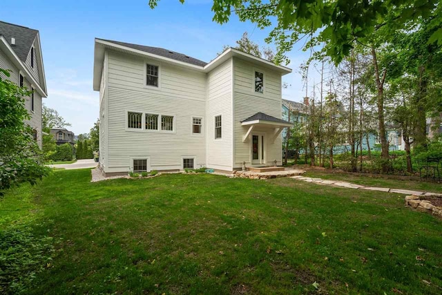 606 State St, Petoskey, MI 49770 - rear view of house with a yard