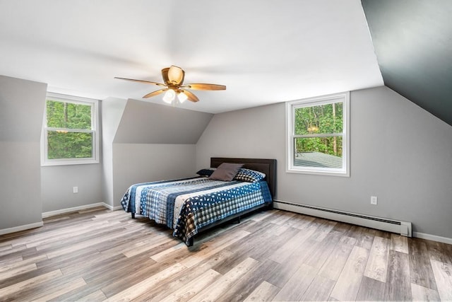 3049 Chippewa Beach Rd, Indian River, MI 49749 - bedroom featuring baseboard heating, wood finished floors, vaulted ceiling, and ceiling fan