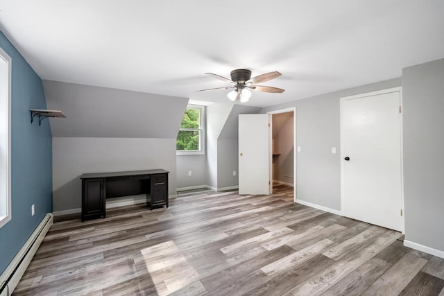 3049 Chippewa Beach Rd, Indian River, MI 49749 - additional living space featuring a baseboard heating unit, ceiling fan, and light wood-style floors