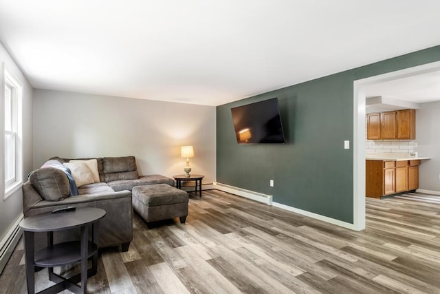 3049 Chippewa Beach Rd, Indian River, MI 49749 - living room with wood finished floors and a baseboard heating unit