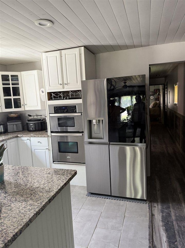 6515 Pincherry Rd, Charlevoix, MI 49720 - kitchen featuring stainless steel appliances, white cabinetry, stone countertops, wood ceiling, and light tile patterned floors