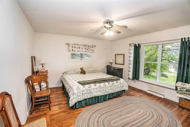 5272 Indian Garden Rd, Petoskey, MI 49770 - bedroom featuring wood finished floors, a baseboard heating unit, and ceiling fan