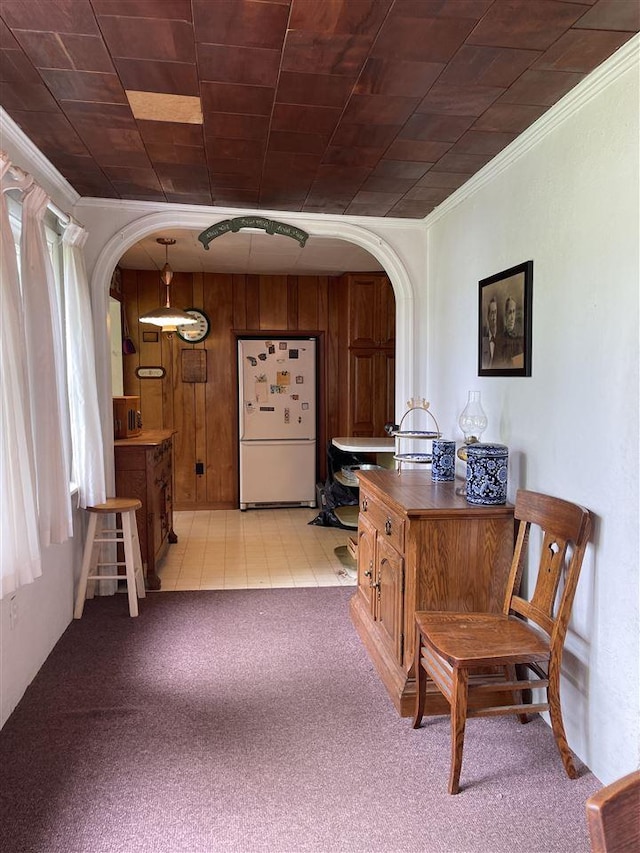 5272 Indian Garden Rd, Petoskey, MI 49770 - bar featuring freestanding refrigerator, arched walkways, crown molding, light colored carpet, and wood walls