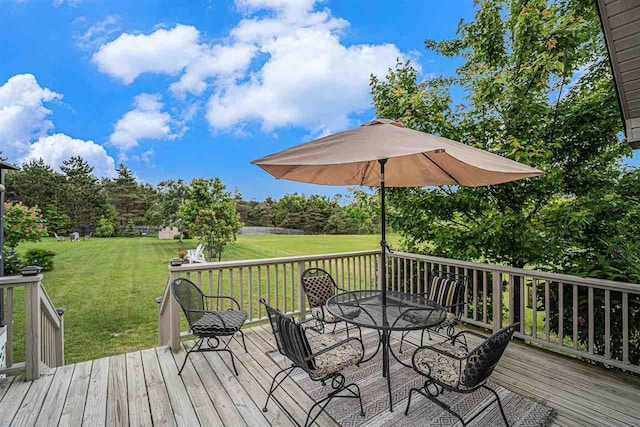 7879 Bay Meadow Dr, Harbor Springs, MI 49740 - wooden deck with outdoor dining area and a lawn
