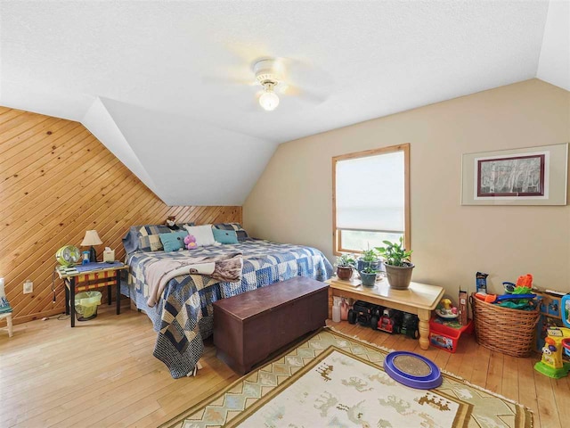 1922 Freeman Rd, East Jordan, MI 49727 - bedroom with lofted ceiling, hardwood / wood-style floors, wood walls, and ceiling fan