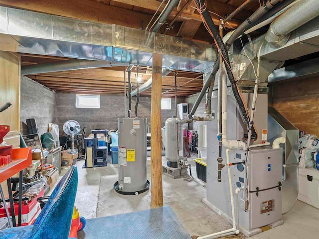 1922 Freeman Rd, East Jordan, MI 49727 - basement with electric water heater, a water pressure tank, and heating unit