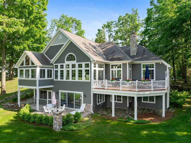 690 Woodhill Unit 6, Harbor Springs, MI 49740 - rear view of property with a sunroom, a patio, a chimney, and a yard