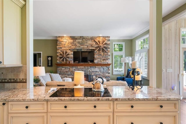 690 Woodhill Unit 6, Harbor Springs, MI 49740 - kitchen featuring cream cabinets, crown molding, black electric stovetop, light stone countertops, and open floor plan