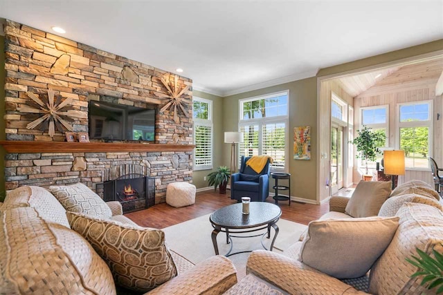 690 Woodhill Unit 6, Harbor Springs, MI 49740 - living area with a stone fireplace, wood finished floors, vaulted ceiling, and ornamental molding