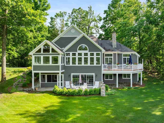 690 Woodhill Unit 6, Harbor Springs, MI 49740 - rear view of house with a lawn, a chimney, and a wooden deck
