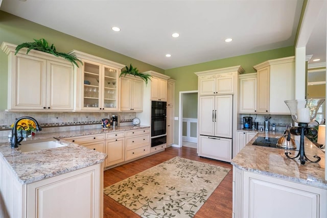 690 Woodhill Unit 6, Harbor Springs, MI 49740 - kitchen with a warming drawer, a peninsula, black appliances, backsplash, and cream cabinetry