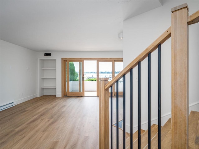 528 E Bay St Unit 30, Harbor Springs, MI 49740 - stairs featuring built in features, wood finished floors, and baseboard heating