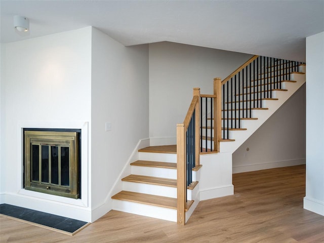 528 E Bay St Unit 30, Harbor Springs, MI 49740 - staircase with wood finished floors and a glass covered fireplace