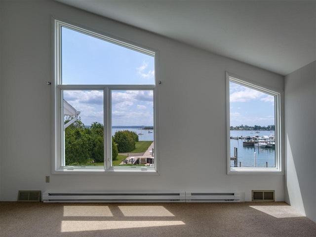 528 E Bay St Unit 30, Harbor Springs, MI 49740 - empty room with a baseboard heating unit, a water view, carpet, and healthy amount of natural light