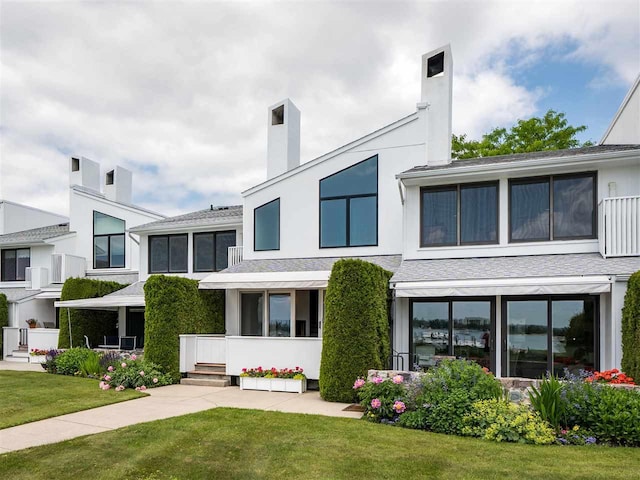528 E Bay St Unit 30, Harbor Springs, MI 49740 - view of front facade with a front lawn and a chimney