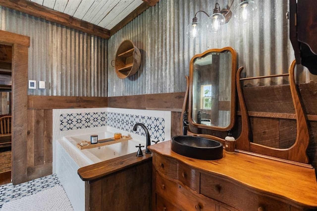 9235 Bailey Rd, East Jordan, MI 49727 - full bathroom with a whirlpool tub, vanity, wallpapered walls, and a wood ceiling with exposed beams
