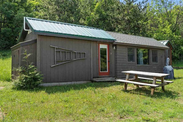 9235 Bailey Rd, East Jordan, MI 49727 - view of front of home featuring a front lawn, a metal roof, and entry steps