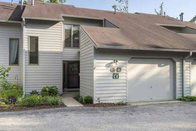 1185 Hideaway Valley Dr Unit 60, Harbor Springs, MI 49740 - view of front of property with a garage and roof with shingles