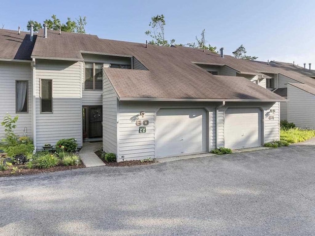 1185 Hideaway Valley Dr Unit 60, Harbor Springs, MI 49740 - view of front of property featuring a shingled roof and an attached garage