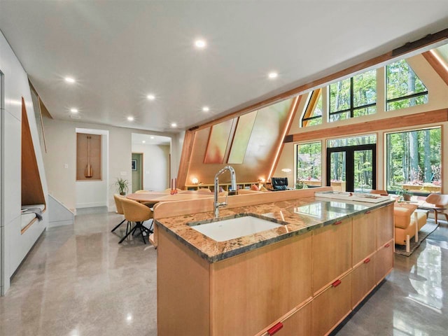 5277 Tyrol Ln, Harbor Springs, MI 49740 - kitchen featuring modern cabinets, an island with sink, light stone counters, recessed lighting, and french doors