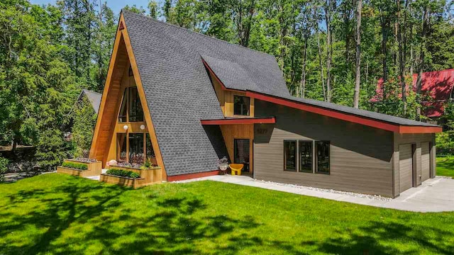 5277 Tyrol Ln, Harbor Springs, MI 49740 - view of front of house with a front lawn, roof with shingles, and a garage