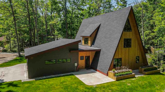 5277 Tyrol Ln, Harbor Springs, MI 49740 - view of front of home with roof with shingles, a front lawn, and a wooded view
