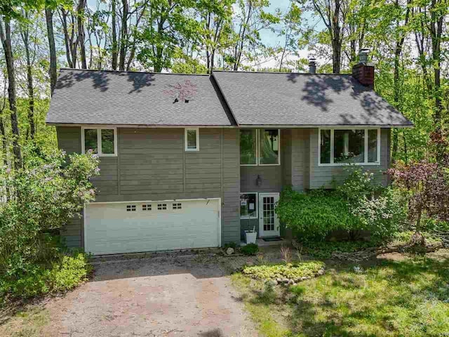 104 Meadow Wood Dr, Harbor Springs, MI 49740 - view of front of property with driveway, a chimney, a garage, and roof with shingles